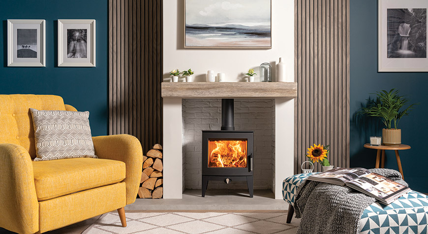 Stovax Futura 5 Poêle à bois, modèle à pieds longs, présenté avec une poutre en céramique à effet bois.